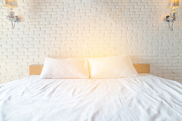 white Pillow on white bed with brickwall background