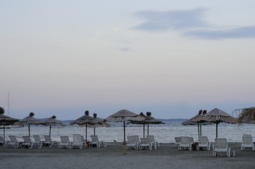 Empty deck chairs and bamboo umbrellas