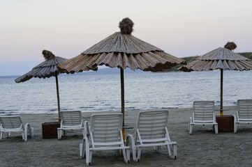 Empty deck chairs and bamboo umbrellas