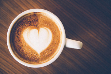 Close up Coffee latte art on wood background , vintage with grai