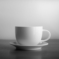 white cup and saucer on wood table