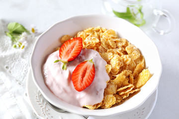 Corn flakes in bowl, yogurt, strawberries and chia seeds