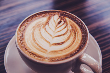 latte art coffee cup on wood table cafe