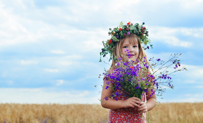 little girl with a wreath his head field of wheat
