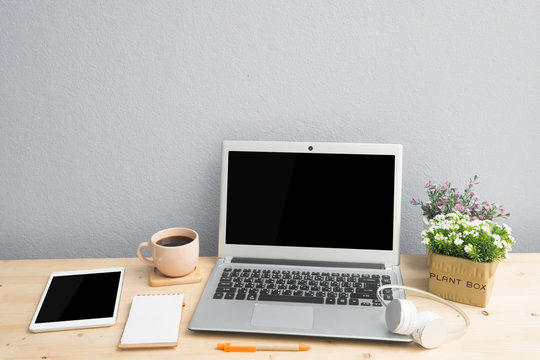 Office desk with blank screen laptop, Note paper, Euphorbia milii flower on terracotta flower pot .
