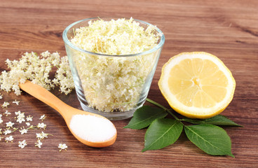 Elderberry flowers and ingredients for preparing juice on rustic board