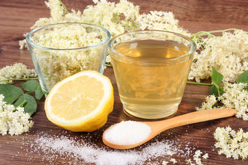 Flowers and juice of elderberry, ingredients for preparing beverage on rustic board