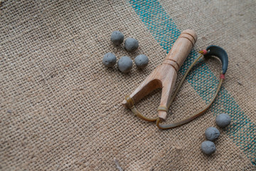 slingshot and ball put on sack