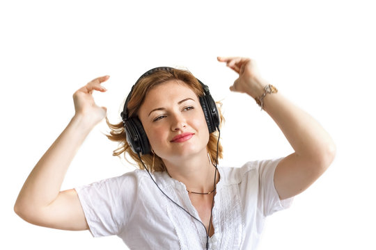 girl in headphones listens to music and dances, in belots shirt,