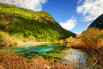 River with azure crystal clear water among wooded mountains