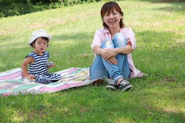 芝生に座る母親と子供