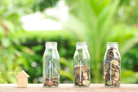 House and coins in jar. The concept of purchase of habitation, b