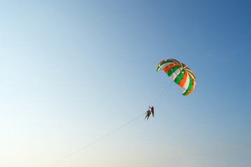 Paraglider flying against the blue sky at sunset time, Blurred background