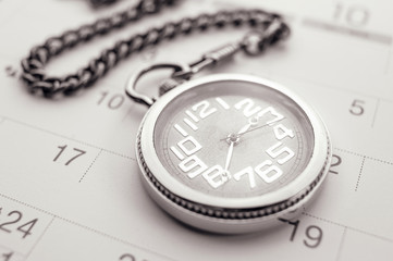 Old pocket watch on calendar page. vintage, black&white