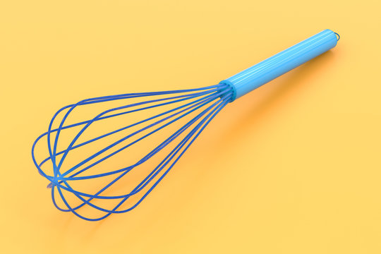 wire whisk on yellow background