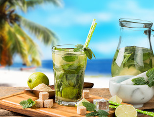 Mojito lime drink on wood with blur beach background