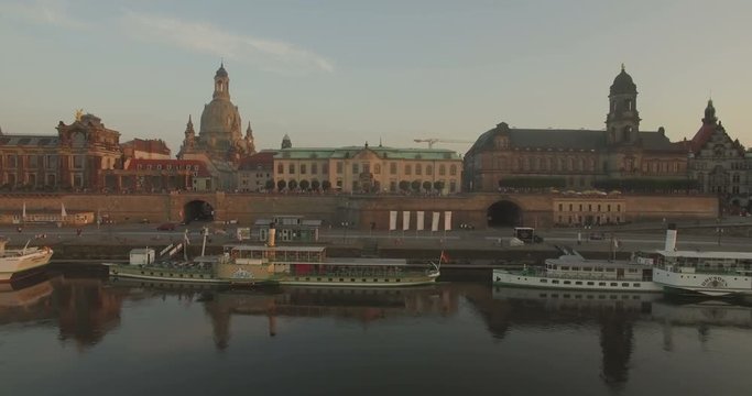 Aerial camera tracks sideways along the River Elbe. The Dresden skyline is in the background
