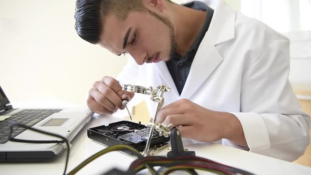 Student in technology fixing computer processing