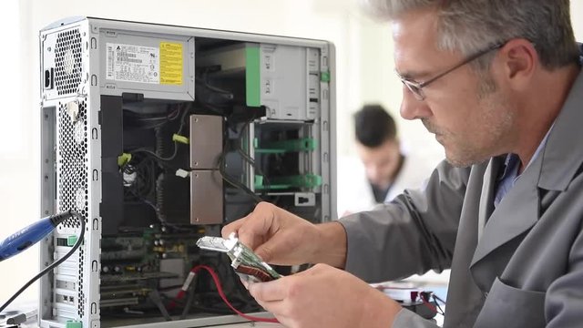 Electrical technician fixing computer hard-drive
