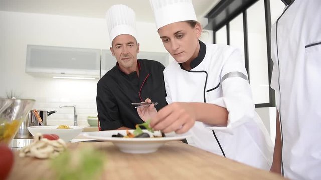 Young chefs presenting dish to teacher