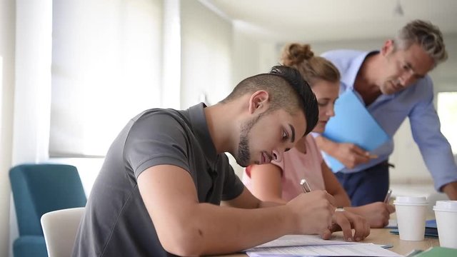 College students filling in registration forms