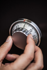 金庫のダイヤルを回す手元