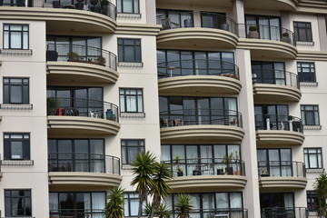 Obraz premium Front view of multi storey apartment building with balconies.