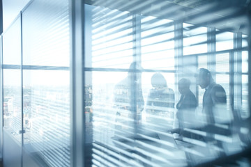 Silhouettes of businesspeople working in room with jalousie