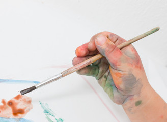 depicting children's hands in the paint with a brush