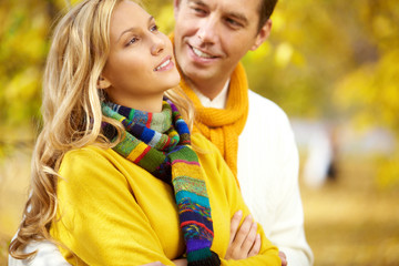 Fototapeta premium A man embracing his girlfriend against autumn background
