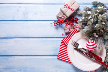 White plate, knife and fork, napkin and christmas decorations in