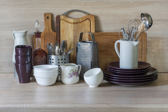 Crockery, tableware, utensils and other different stuff on wooden table-top.Kitchen still life as background for design.  Image with copy space.