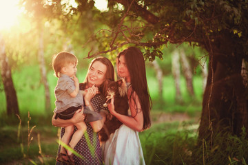 Beautiful happy family resting in nature. Two women - mom and aunt play with a boy in the Park....