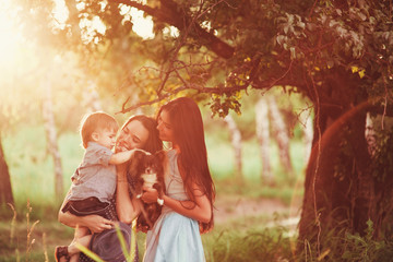 Beautiful happy family resting in nature. Two women - mom and aunt play with a boy in the Park....