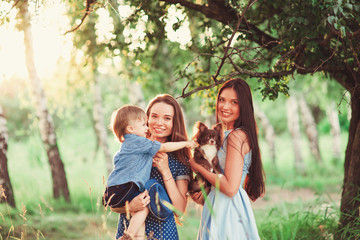 Beautiful happy family resting in nature. Two women - mom and aunt play with a boy in the Park....