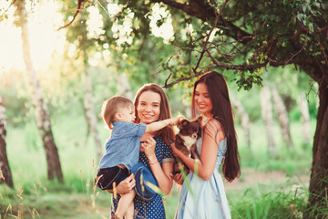 Beautiful happy family resting in nature. Two women - mom and aunt play with a boy in the Park....