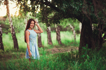 Naklejka premium Portrait of pretty girl near the tree in the park. Concept of youth and natural beauty. soft focus