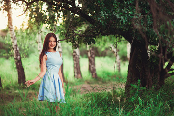 Naklejka premium Portrait of pretty girl near the tree in the park. Concept of youth and natural beauty. soft focus