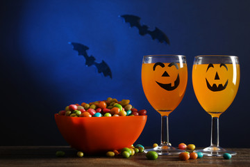 Orange drink with candy on a dark background. Halloween.