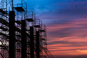 Silhouette of scaffolding in the construction site before to night time or sunset time. worker...