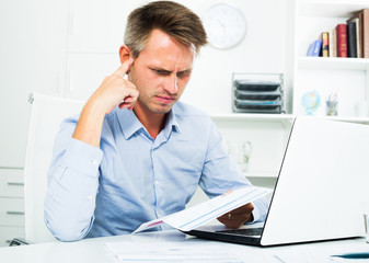 Frustrated man working on laptop