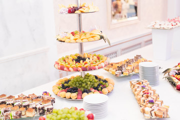 Delicious and tasty dessert table with cupcakes shots at reception closeup