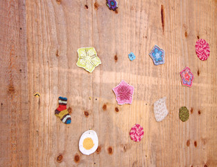 a lot of multicolored small crocheted things hanging on wooden wall