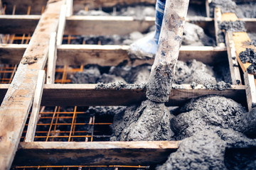 construction worker pouring cement on stairs, creating sidewalks and stairs on new building site