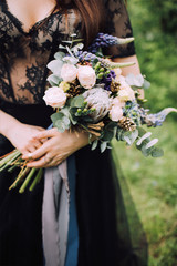 Bride in black dress with wedding bouquet in her hands 