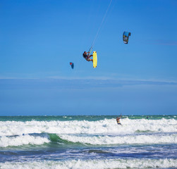 Athletic man jump on kite surf board in sea waves