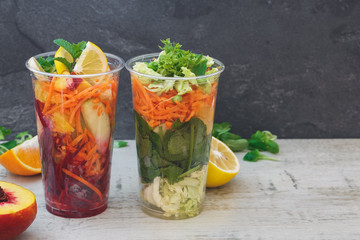 Fruit and vegetable salad arranged in take away clear plastic cups, selective focus