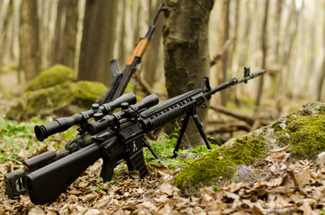 Sniper rifle on bipod on forest background