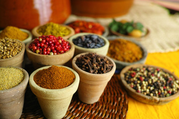 Collection of different spices in old clay bowls in colorful oriental style