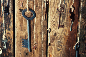 Many keys hanging on a string. Wooden background. Selective focus